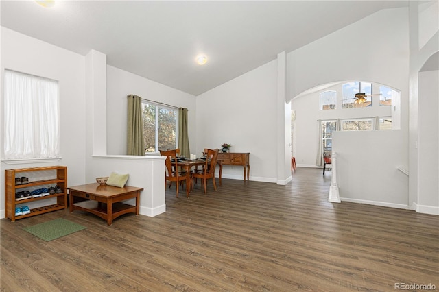 living area featuring dark hardwood / wood-style floors, ceiling fan, and high vaulted ceiling