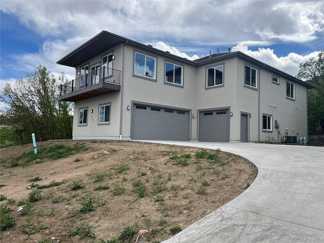 485 Cardiff Cir, Colorado Springs, CO 80906 - view of property exterior with a garage, stucco siding, a balcony, concrete driveway, and central air condition unit