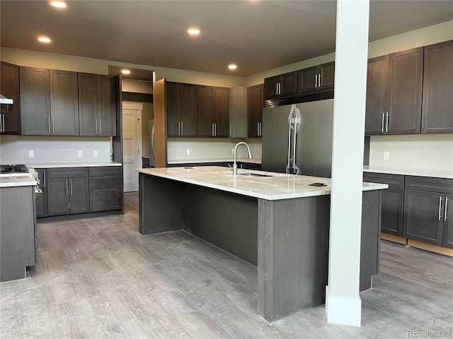 485 Cardiff Cir, Colorado Springs, CO 80906 - kitchen with built in refrigerator, a sink, light wood-style floors, an island with sink, and recessed lighting