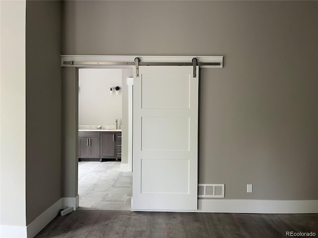 485 Cardiff Cir, Colorado Springs, CO 80906 - spare room with a barn door, baseboards, and wood finished floors