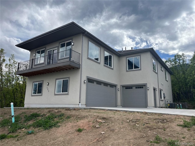 485 Cardiff Cir, Colorado Springs, CO 80906 - view of front of home featuring an attached garage, a balcony, stucco siding, central AC unit, and driveway