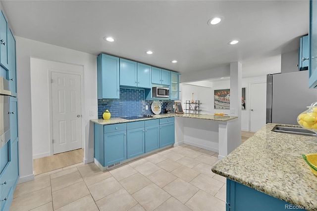 1552 W Caley Ave, Littleton, CO 80120 - kitchen featuring stainless steel appliances, blue cabinetry, light tile patterned floors, backsplash, and recessed lighting