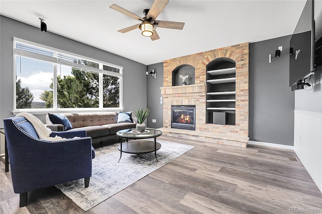 4069 Copper Ct, Castle Rock, CO 80104 - living room featuring a ceiling fan, a brick fireplace, wood finished floors, and built in features