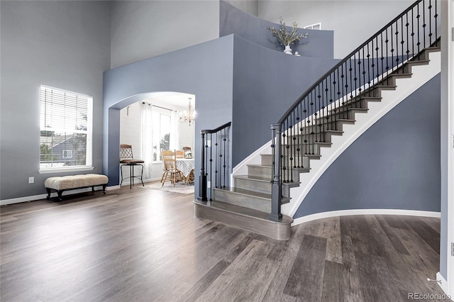 4069 Copper Ct, Castle Rock, CO 80104 - staircase with a high ceiling, wood finished floors, a chandelier, and arched walkways