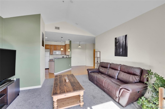 living room with visible vents, light colored carpet, baseboards, and lofted ceiling