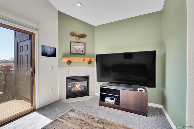 carpeted living room featuring baseboards and a fireplace