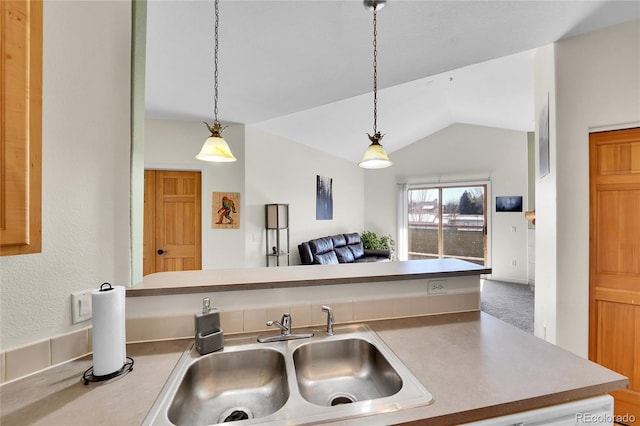 kitchen with light countertops, decorative light fixtures, and a sink