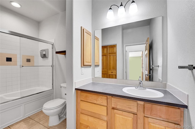 full bath featuring tile patterned flooring, toilet, vanity, and shower / bath combination with glass door