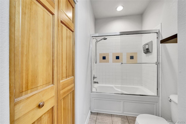 full bath featuring tile patterned floors, combined bath / shower with glass door, and toilet