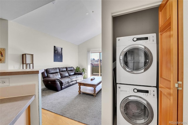 laundry room with stacked washer / dryer and light wood finished floors