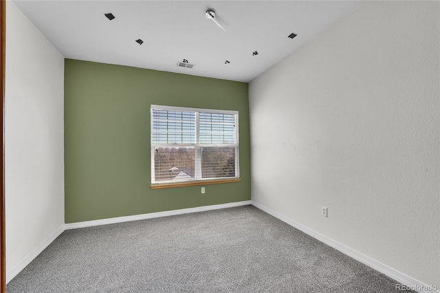 spare room featuring visible vents, baseboards, and carpet flooring