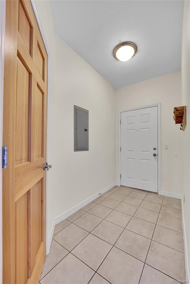 doorway to outside with electric panel, light tile patterned floors, and baseboards