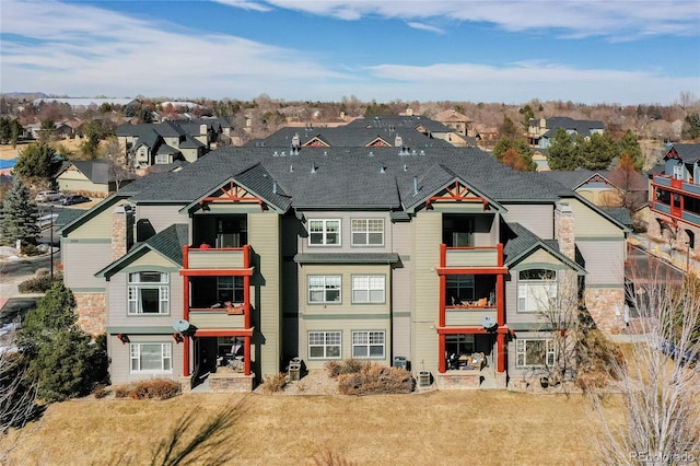 view of front of home featuring a residential view, a balcony, and a front yard