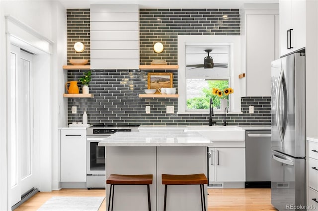 2995 Yates St, Denver, CO 80212 - kitchen featuring stainless steel appliances, decorative backsplash, open shelves, and a ceiling fan