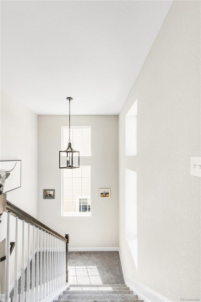 7678 S Old Hammer Way, Aurora, CO 80016 - staircase featuring carpet flooring, a chandelier, and baseboards