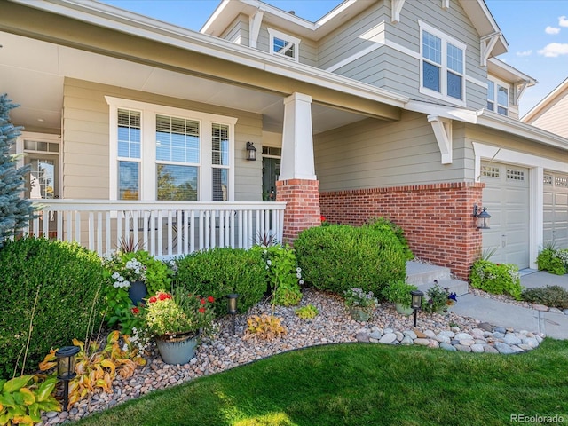 doorway to property with covered porch and a garage