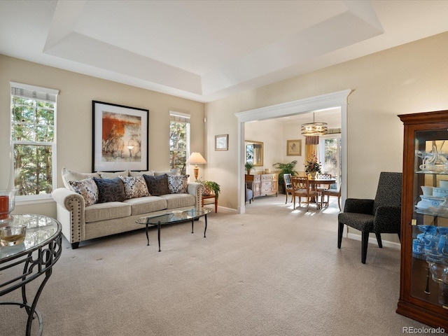 carpeted living room with a tray ceiling and plenty of natural light