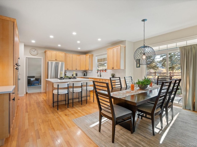 dining area featuring light hardwood / wood-style floors, a notable chandelier, and sink