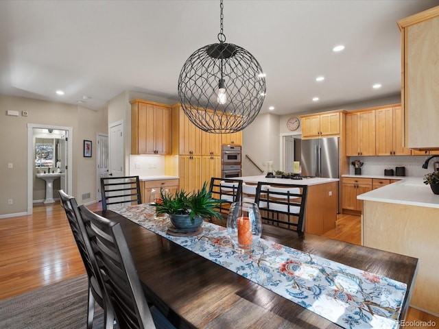 dining room featuring sink and light hardwood / wood-style flooring