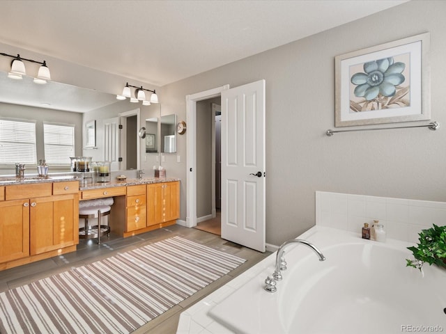 bathroom with vanity and tiled bath