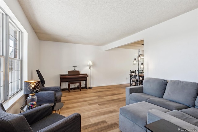 7822 W Ottawa Pl, Littleton, CO 80128 - living area with light wood-style floors, a textured ceiling, plenty of natural light, and baseboards