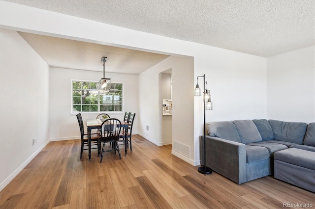 7822 W Ottawa Pl, Littleton, CO 80128 - dining room with light wood finished floors, baseboards, and a textured ceiling
