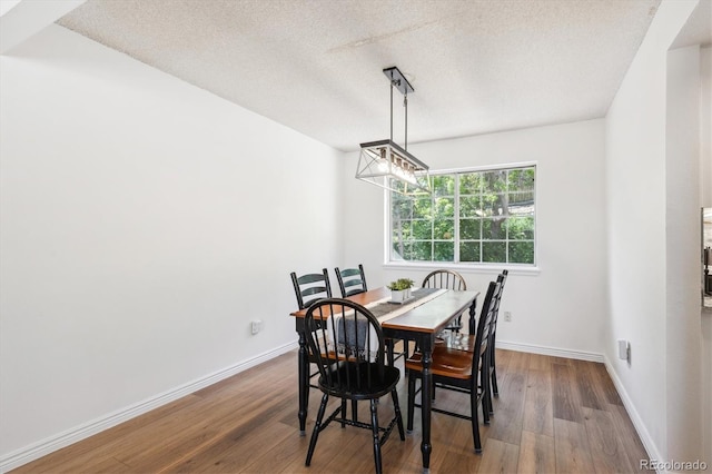 7822 W Ottawa Pl, Littleton, CO 80128 - dining room with wood finished floors, a textured ceiling, and baseboards