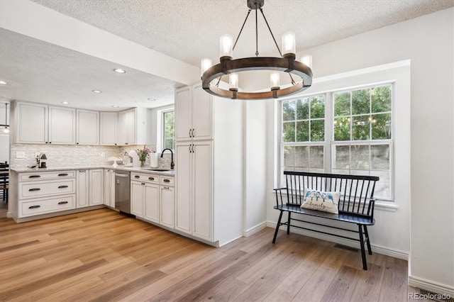 7822 W Ottawa Pl, Littleton, CO 80128 - kitchen featuring dishwasher, a chandelier, a textured ceiling, light wood-style floors, and a sink