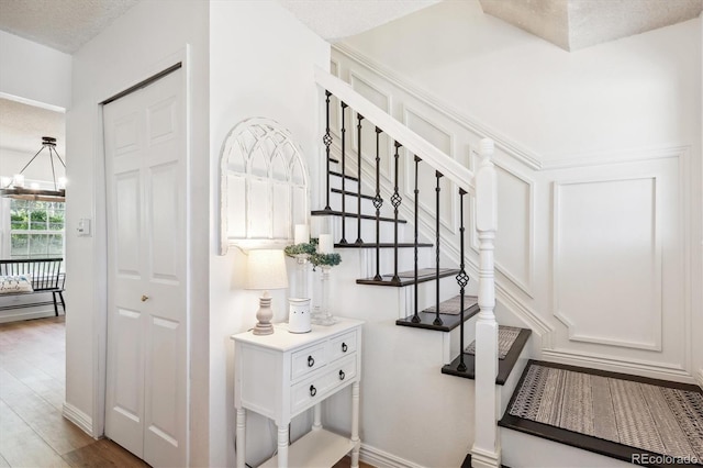 7822 W Ottawa Pl, Littleton, CO 80128 - stairs featuring a chandelier and wood finished floors