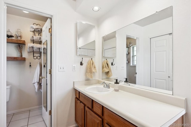 7822 W Ottawa Pl, Littleton, CO 80128 - bathroom with toilet, vanity, tile patterned flooring, and baseboards