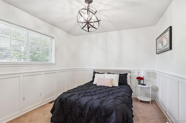 7822 W Ottawa Pl, Littleton, CO 80128 - bedroom with light carpet, wainscoting, a textured ceiling, and a decorative wall