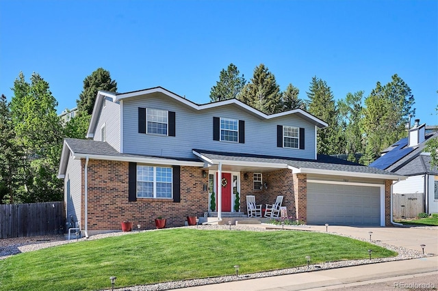 7822 W Ottawa Pl, Littleton, CO 80128 - traditional-style house featuring brick siding, driveway, and covered porch