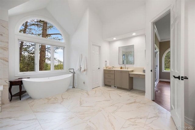 120 Silver Leaf Way, Castle Rock, CO 80108 - full bath featuring marble finish flooring, vanity, a soaking tub, baseboards, and a towering ceiling