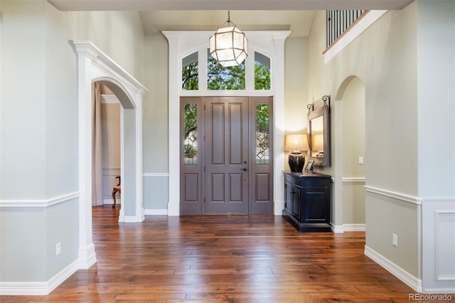 120 Silver Leaf Way, Castle Rock, CO 80108 - foyer entrance with arched walkways, dark wood finished floors, a towering ceiling, and baseboards