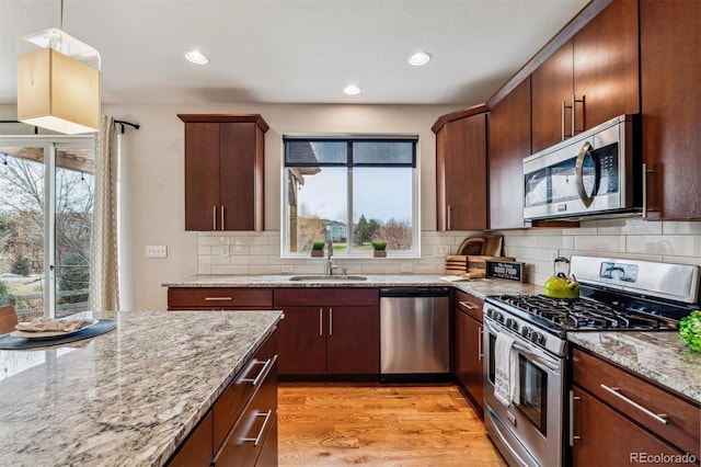 kitchen with light hardwood / wood-style floors, plenty of natural light, stainless steel appliances, and sink