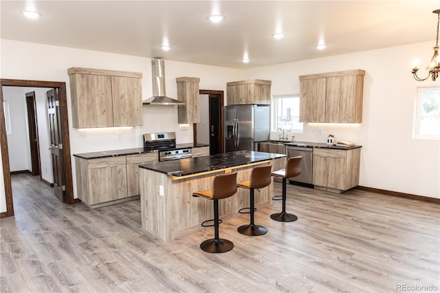 104 Dotson St, Manassa, CO 81141 - kitchen featuring stainless steel appliances, wall chimney range hood, light brown cabinets, a kitchen bar, and dark countertops
