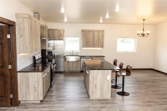 104 Dotson St, Manassa, CO 81141 - kitchen with stainless steel appliances, light brown cabinets, a kitchen breakfast bar, and healthy amount of natural light