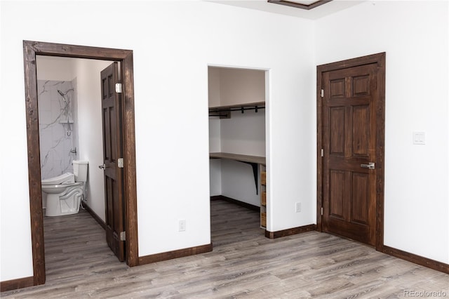 104 Dotson St, Manassa, CO 81141 - unfurnished bedroom featuring light wood-style floors, a spacious closet, and connected bathroom