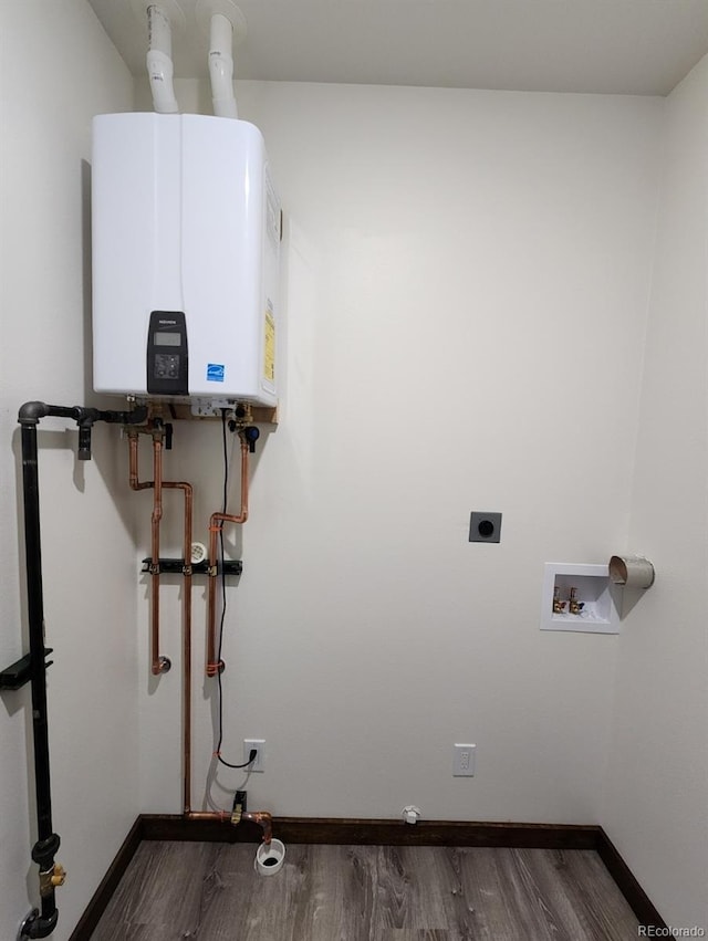 104 Dotson St, Manassa, CO 81141 - washroom with water heater, dark wood finished floors, electric dryer hookup, and hookup for a washing machine