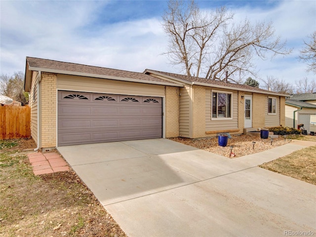 ranch-style home featuring concrete driveway, a garage, fence, and brick siding