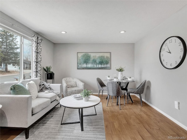 living room featuring recessed lighting, baseboards, and light wood finished floors