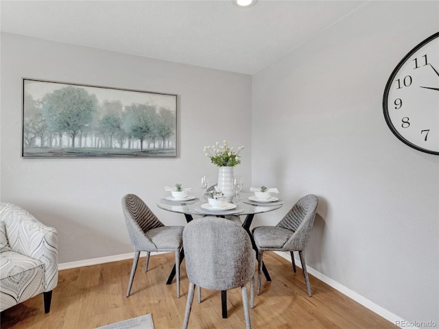 dining space featuring baseboards and wood finished floors