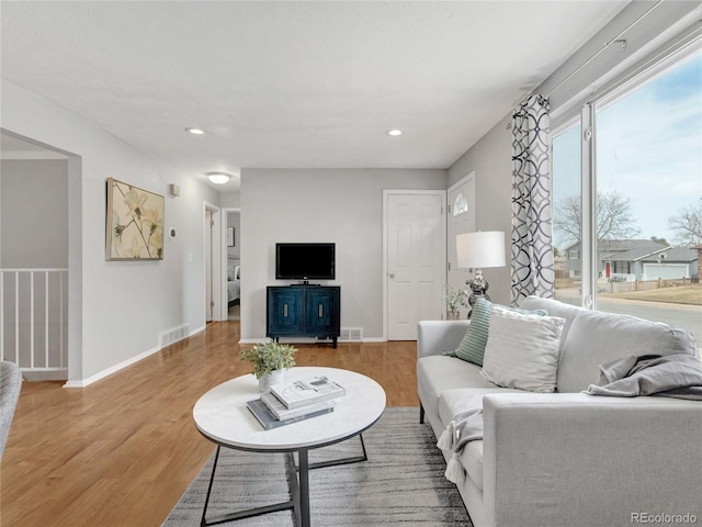 living room featuring recessed lighting, visible vents, light wood-style flooring, and baseboards