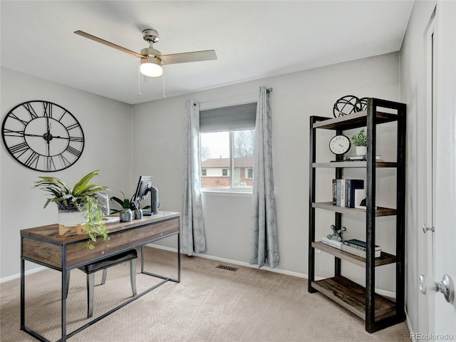 carpeted office space with baseboards, visible vents, and ceiling fan