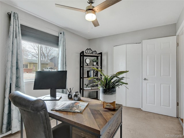 home office featuring light colored carpet and a ceiling fan