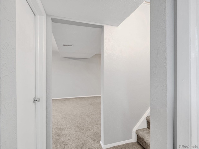 stairs with visible vents, baseboards, and carpet