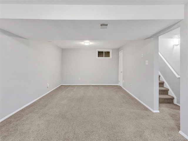 finished basement featuring stairway, carpet flooring, and baseboards