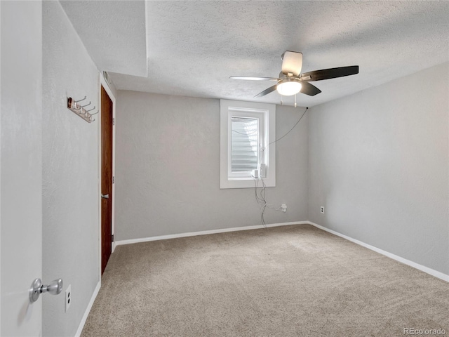 empty room featuring baseboards, carpet floors, a textured ceiling, and ceiling fan