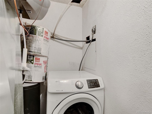 washroom featuring laundry area, washer / clothes dryer, and a textured wall