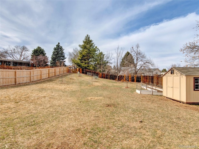 view of yard with a storage unit, a fenced backyard, and an outdoor structure